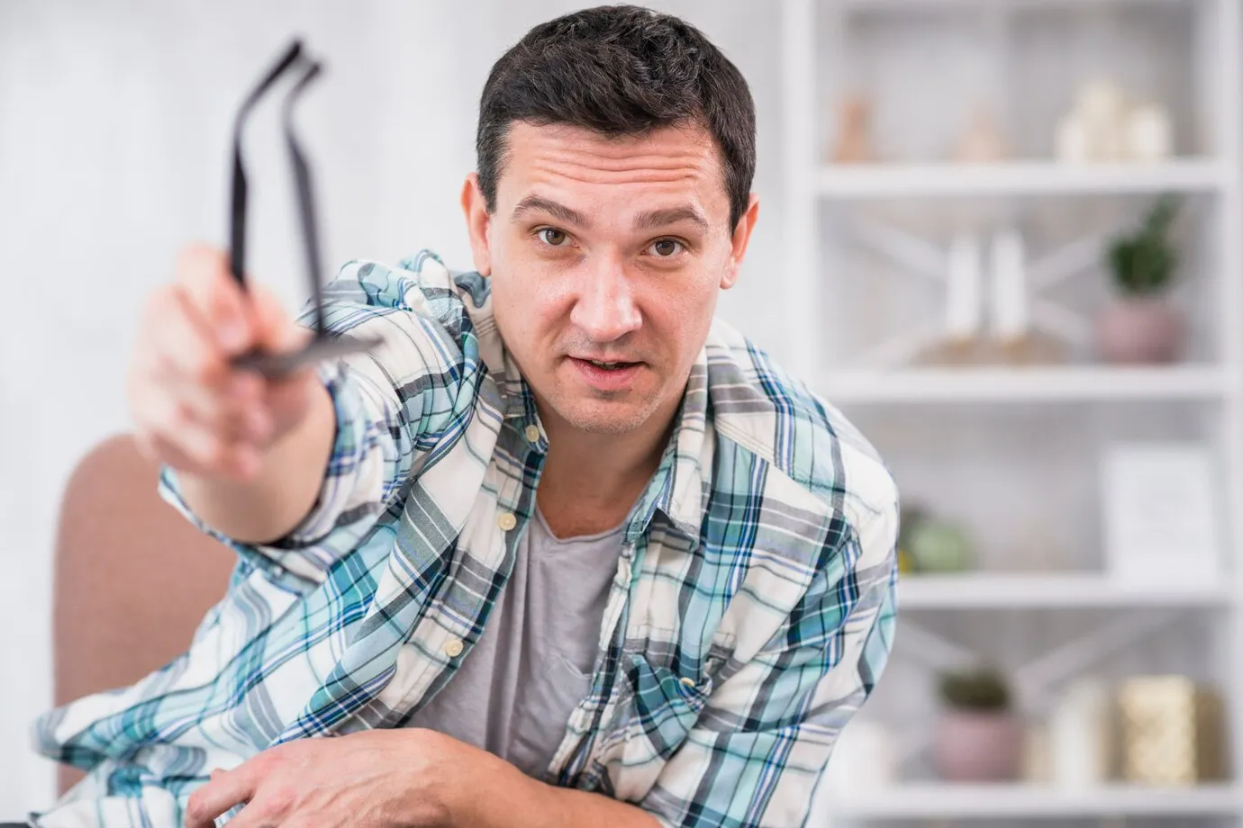 man-holding-eyeglasses-stretched